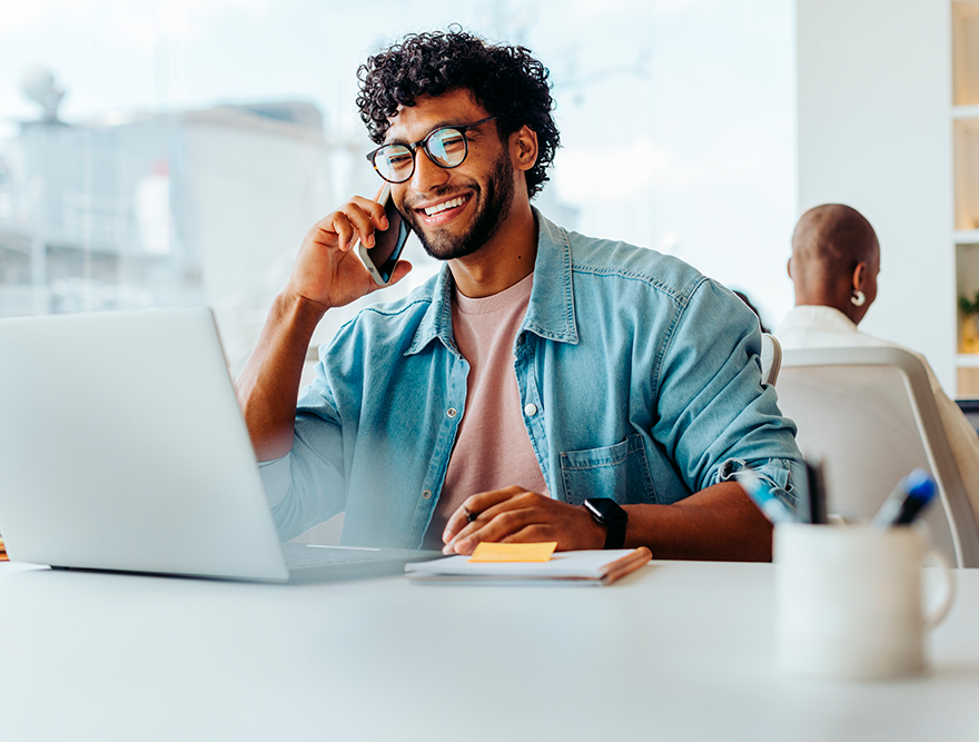 Jovem em ambiente de trabalho moderno, demonstrando confiança após investir em capacitação profissional para aumentar sua empregabilidade.